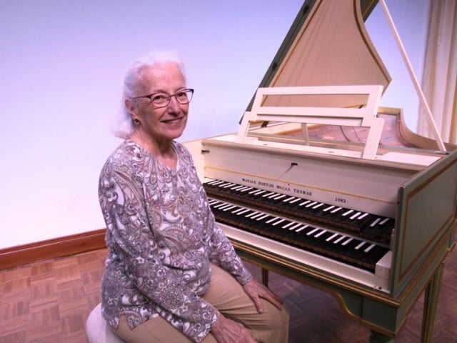 Marian sitting next to her harpsichord