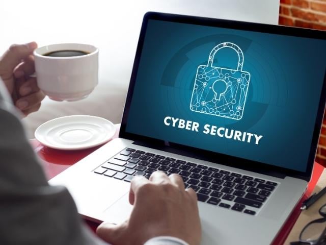 hands on laptop and screen reads "cyber security" with lock image 