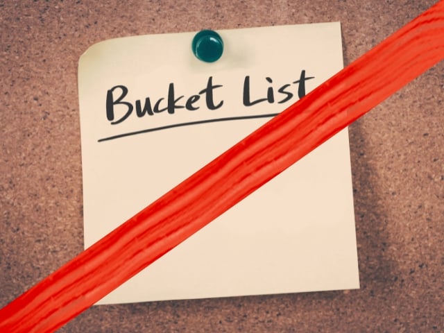 Bucket List written on post it note with red slash through image