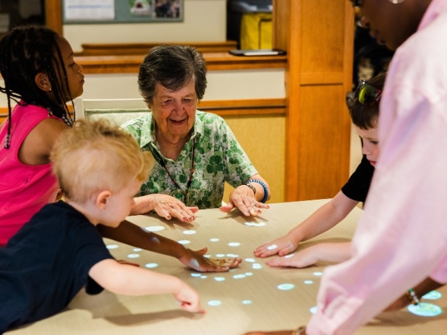 students and resident playing game on table 