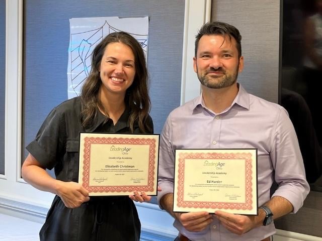 young woman and man holding certificates 