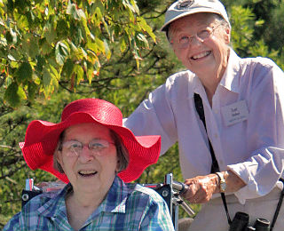 Lady in a red hat being pushed in a wheelchair