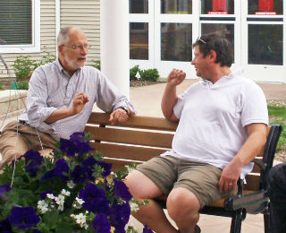 Two men talking in a garden