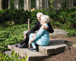 Older couple embracing on stone steps