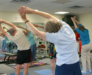 Women with hands over heads stretching to side