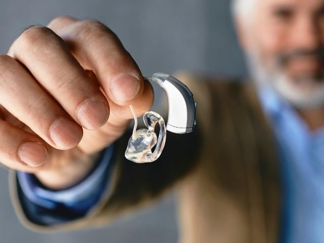 man holding hearing aid 