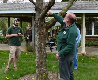 2 men standing by a tree