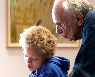 older adult man helping a young boy