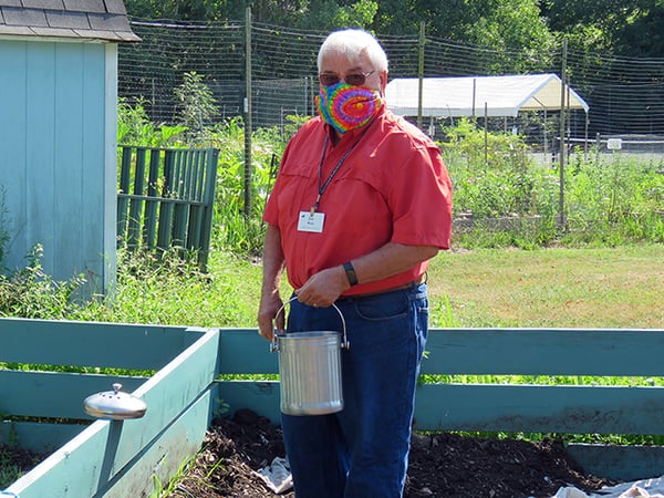 man adding to compost pile