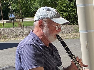 man playing clarinet outside