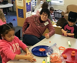 Betsy M with children - for blogKendal resident and early learning center children