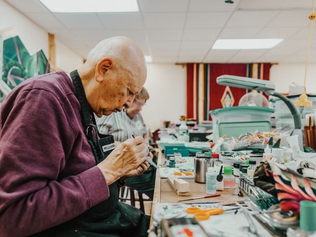 man working in craft room on model airplane 