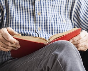 Older adult man enjoying a good book.