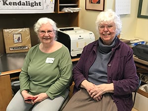  Two women sitting at desks in an office