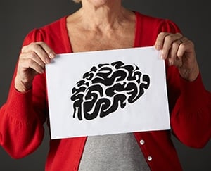 Senior woman holding an ink drawing of a brain.